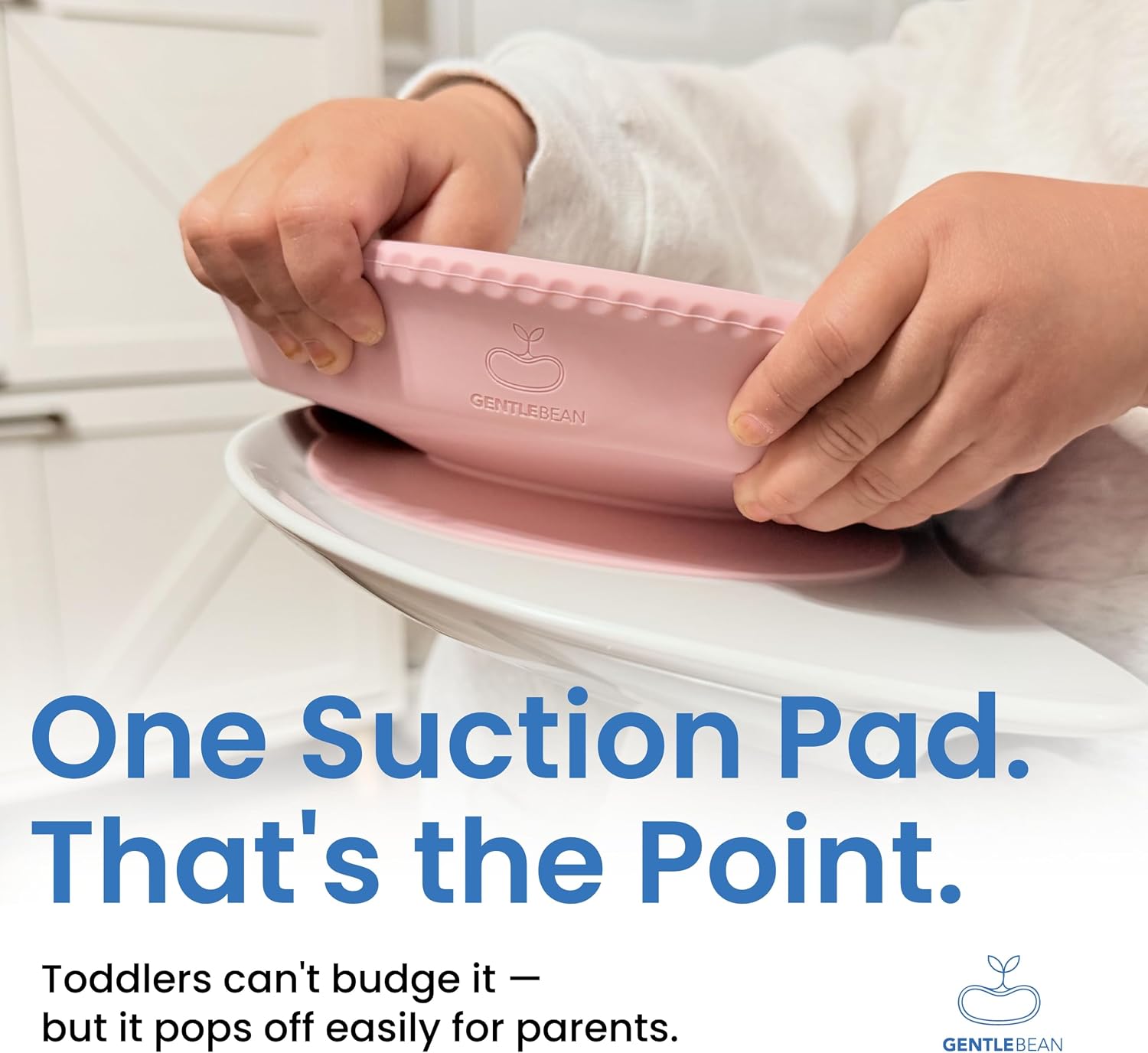 A person's hands holding a pink Gentle Bean one suction pad, demonstrating how it does not pop off easily from a white high chair tray. The image includes text overlays explaining that toddlers cannot easily budge the suction, but parents can. 